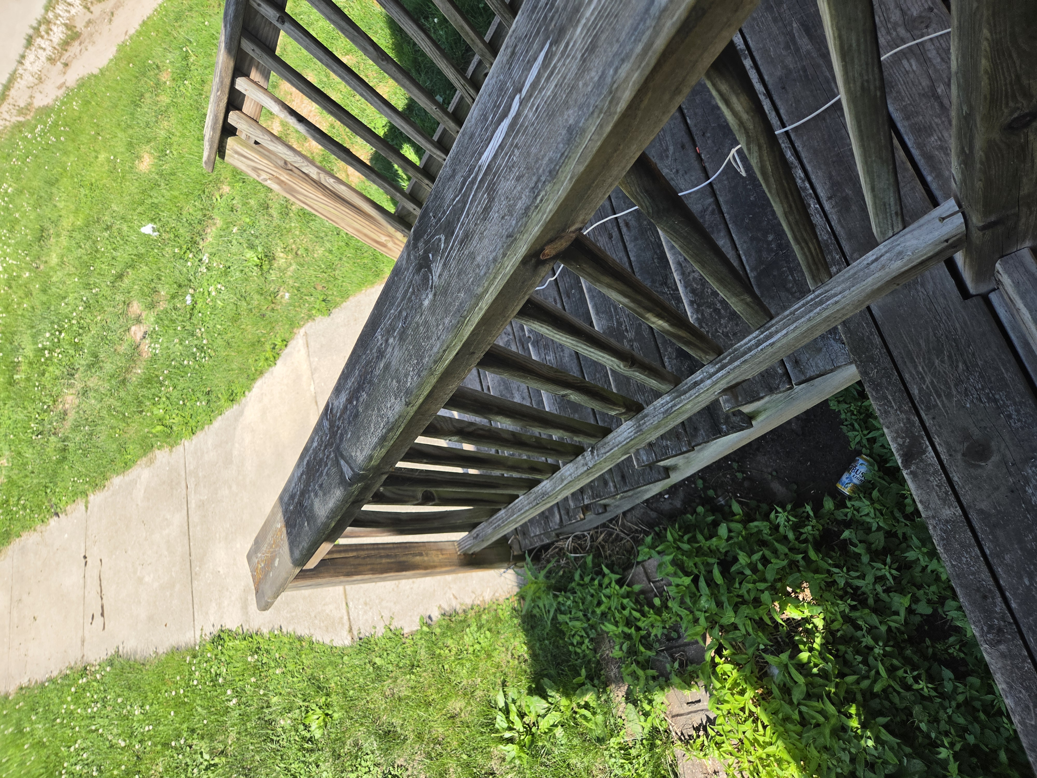 Damaged wooden porch steps and railing from a high angle, Ames rental property turnover project.