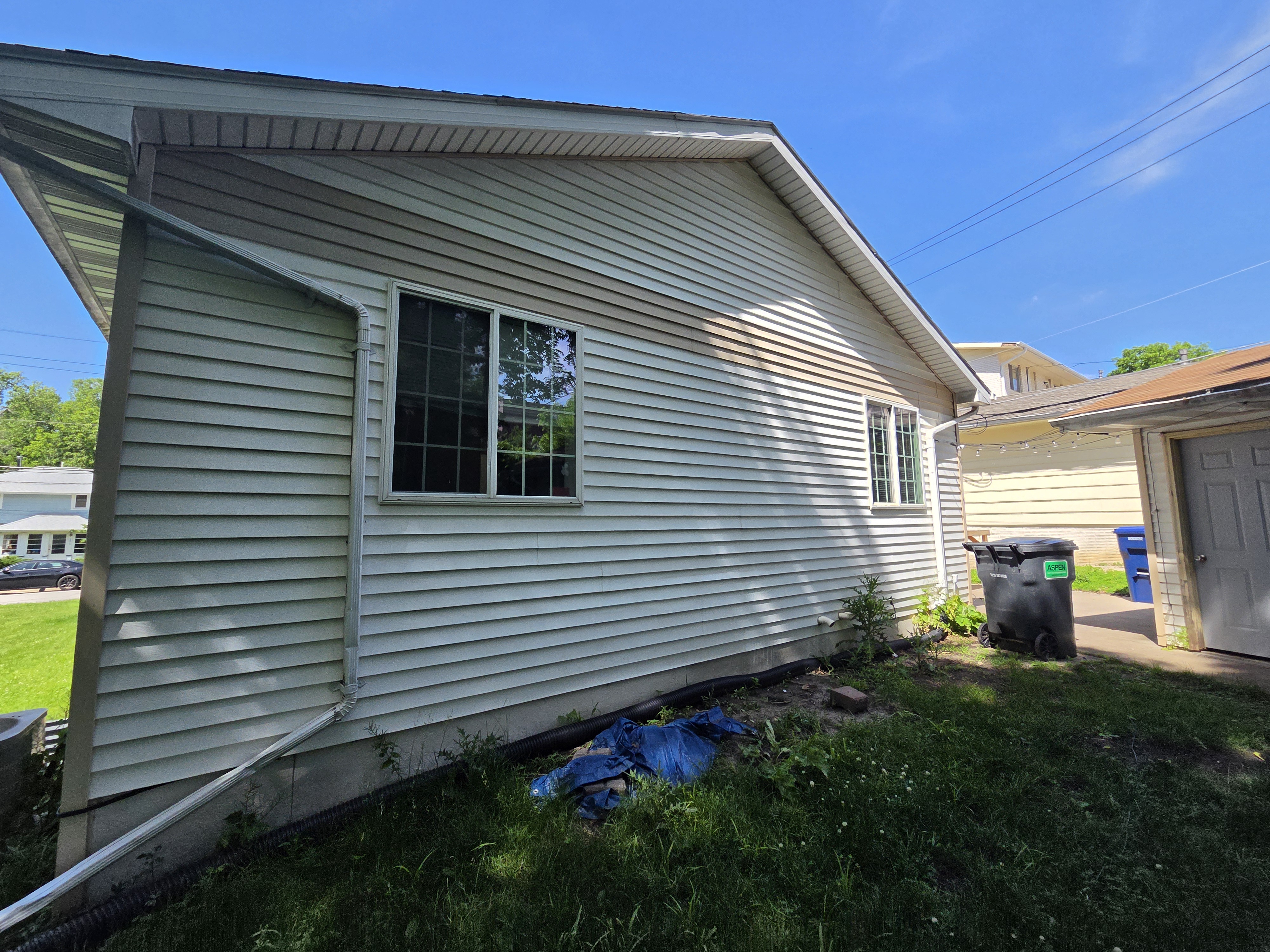 Side exterior of a house with clean siding after power washing, Ames rental property turnover project.