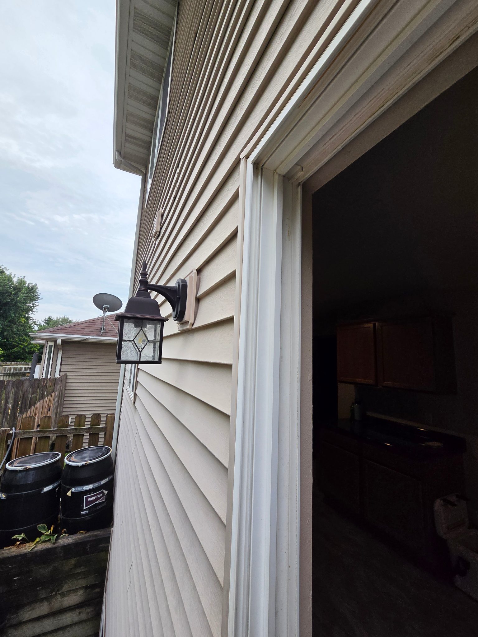 Detail image of the exterior white PVC brick mold around a new patio door in Ames, installed on beige siding.