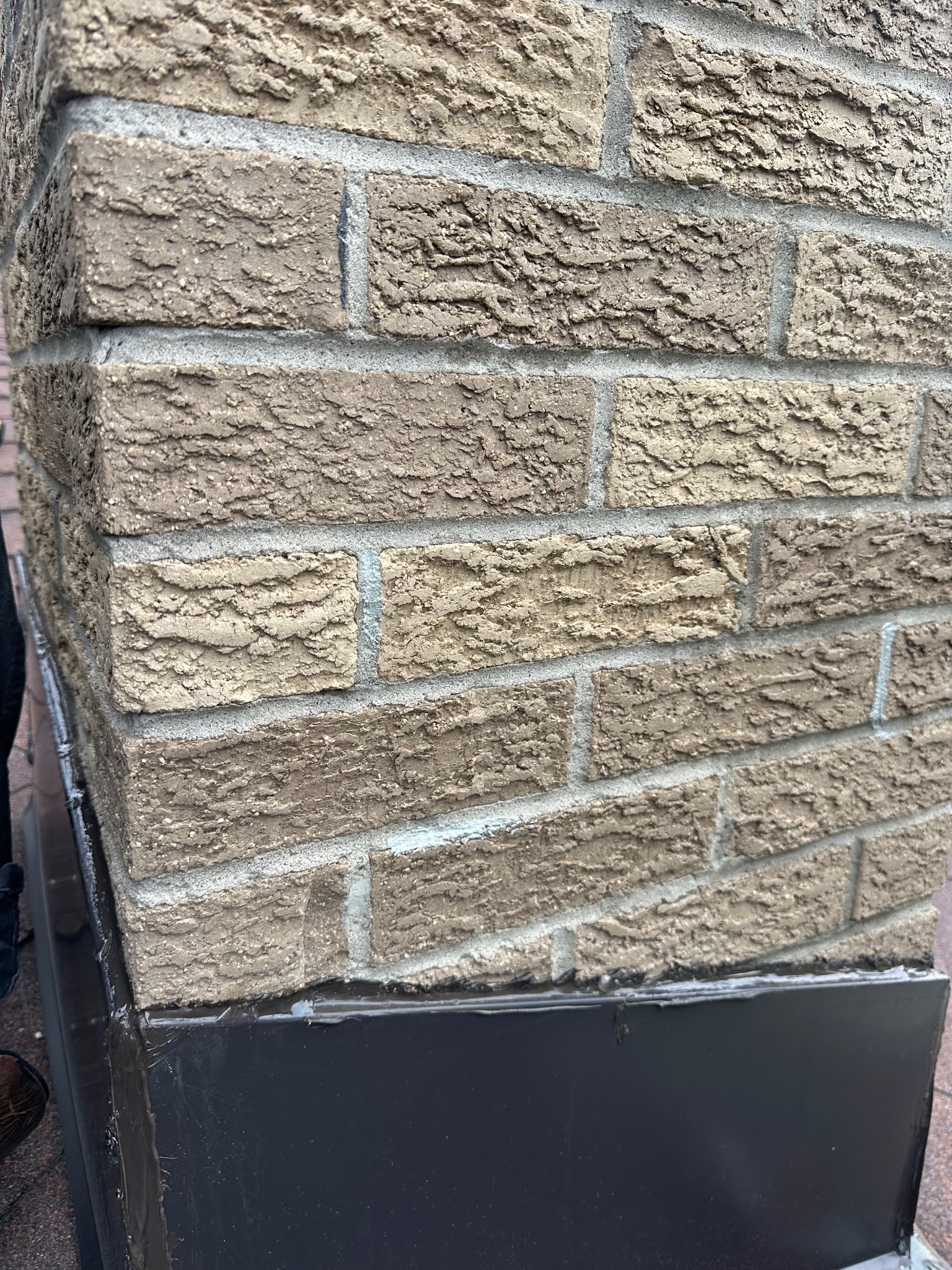 Close-up of chimney flashing and mortar joints on a roof in Ames handyman project.