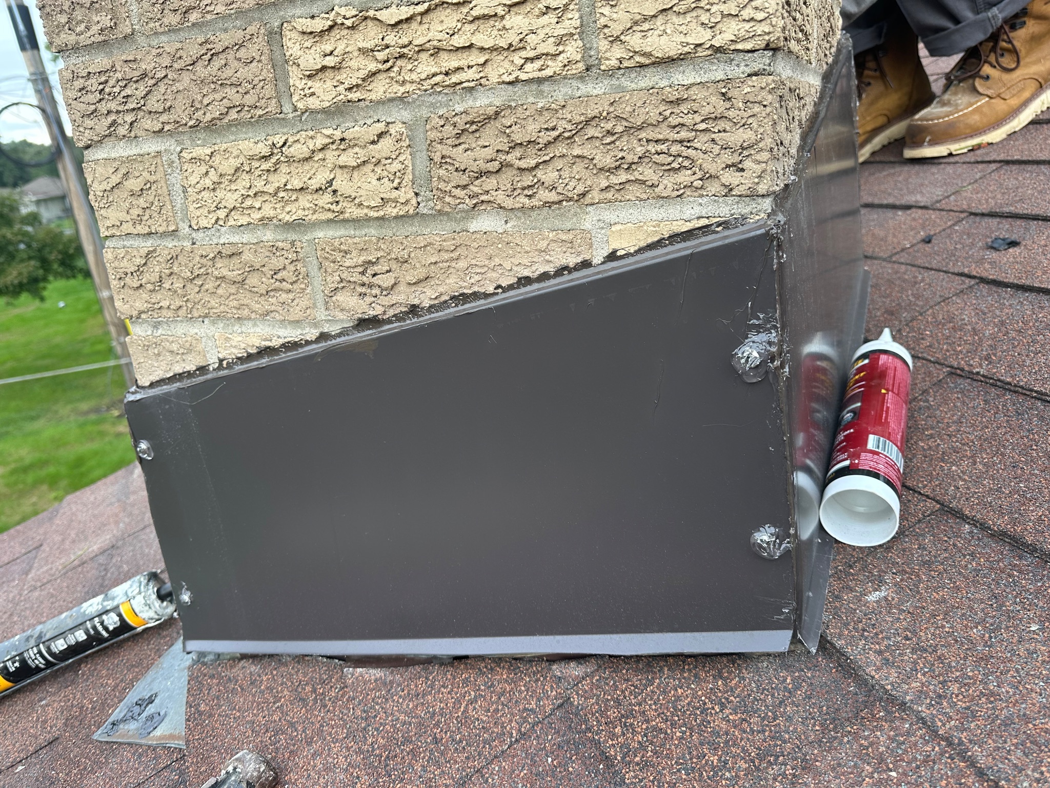 Chimney flashing with visible sealant applications on a roof in Ames handyman project.