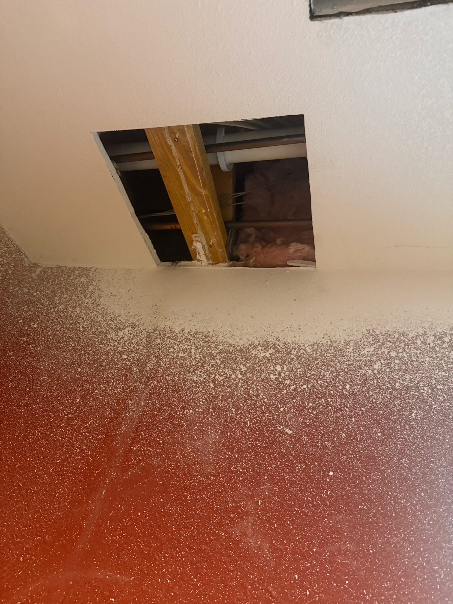 Ceiling drywall opening showing structural elements in Ames, handyman project.