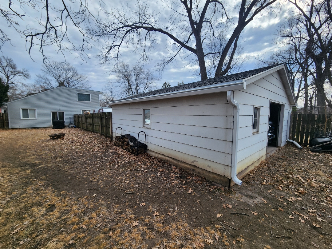 Before photo of a garage exterior in Ames with existing siding and door