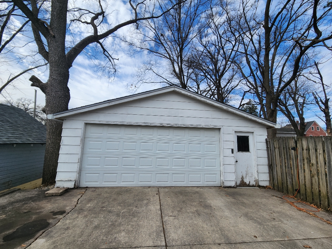 Before photo of the side of a garage in Ames with old siding