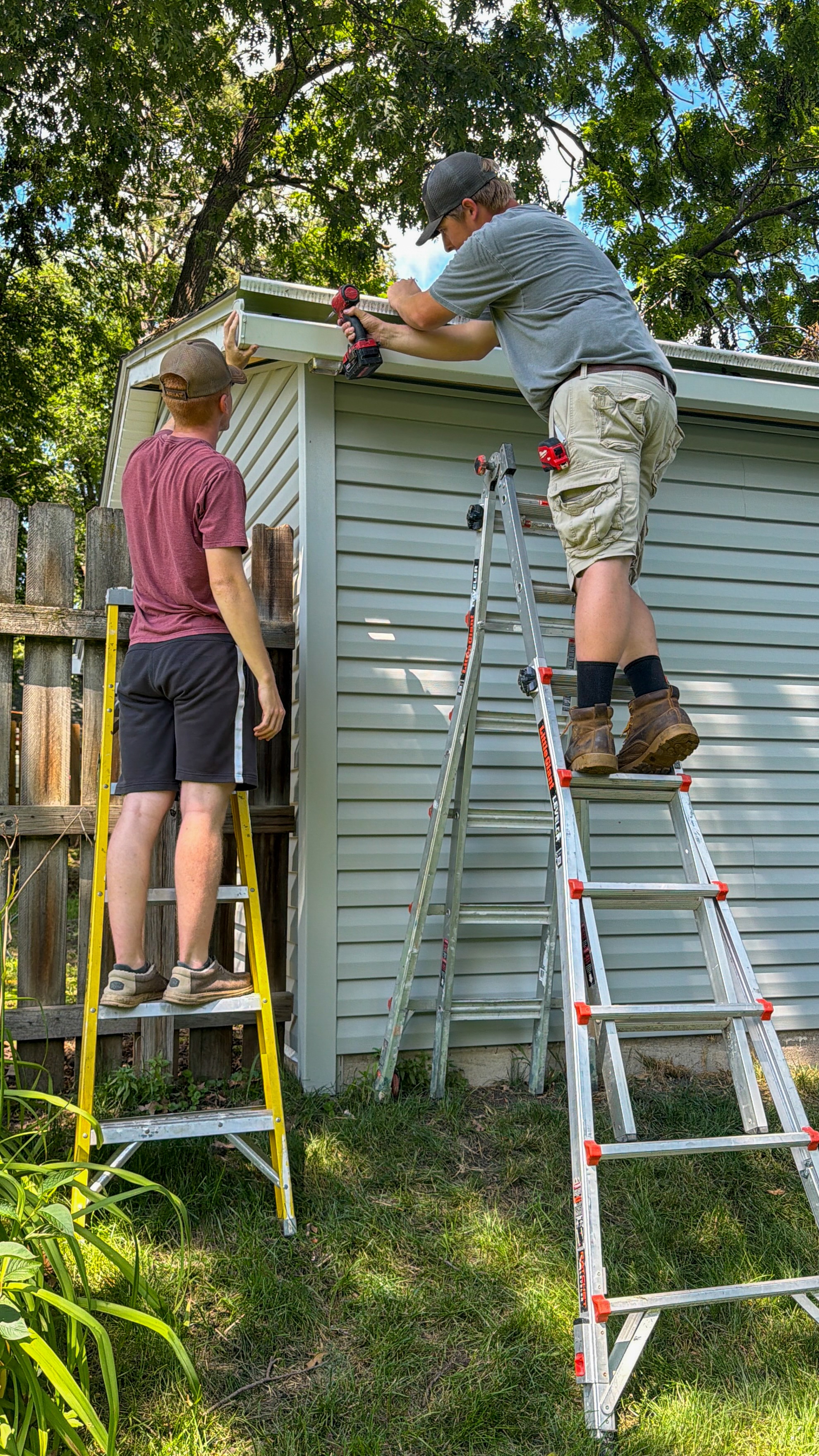 During remodel photo of a garage in Ames with new siding, showing workers installing trim