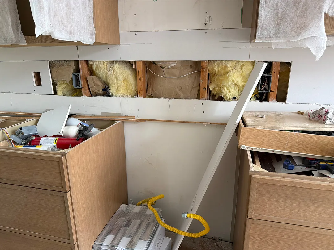 During renovation photo showing exposed studs and framing after wall removal in a Des Moines kitchen.
