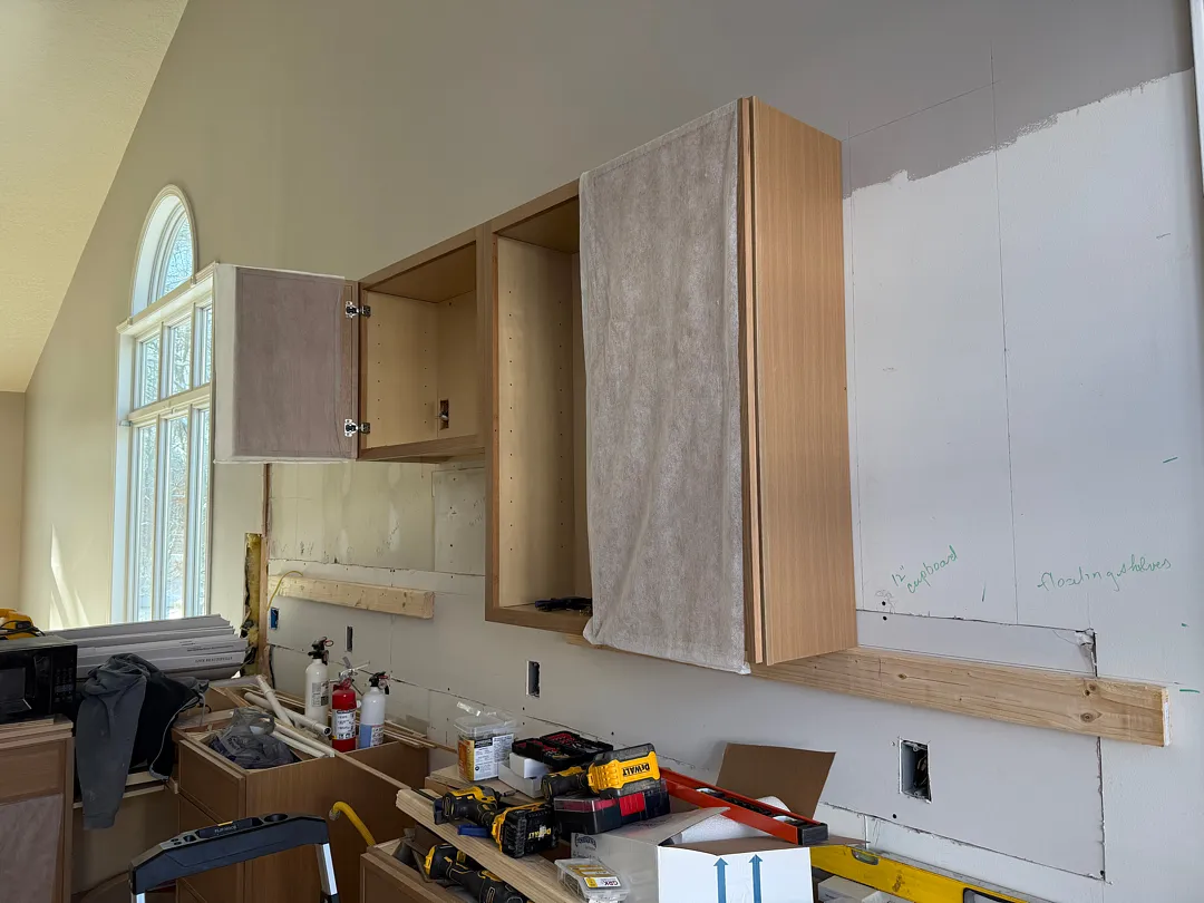 During renovation photo of kitchen with new subflooring and framing visible in Des Moines.