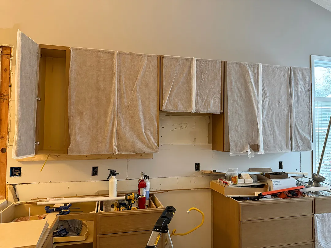 During renovation photo depicting a kitchen space with new drywall and cabinet installation underway in Des Moines.