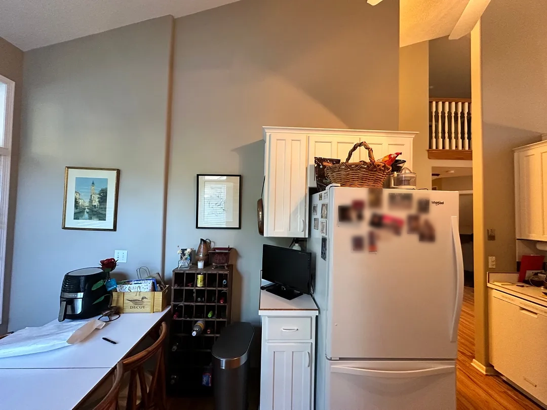Before photo of a kitchen area with a wall separating it from an adjacent dining space in Des Moines.